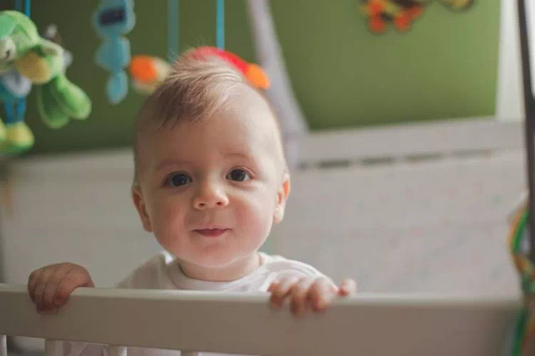Bébé debout dans son lit