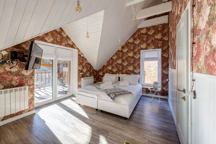 Chambre mansardée habillée avec un joli papier peint