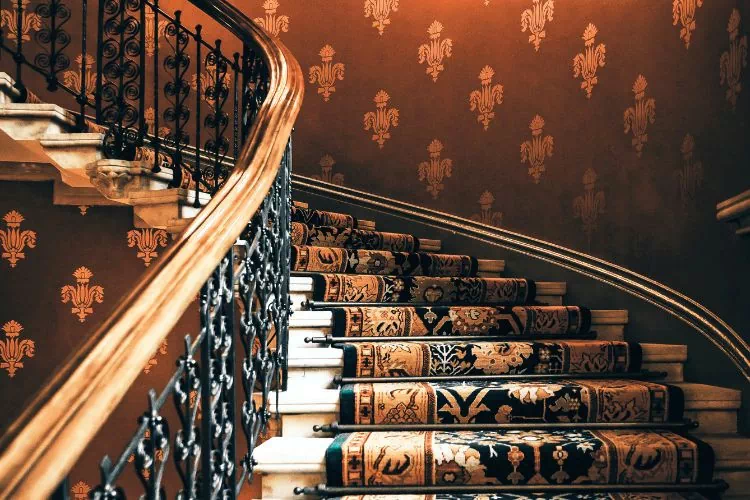 Cage d'escalier habillé d'un papier peint aux tons chauds