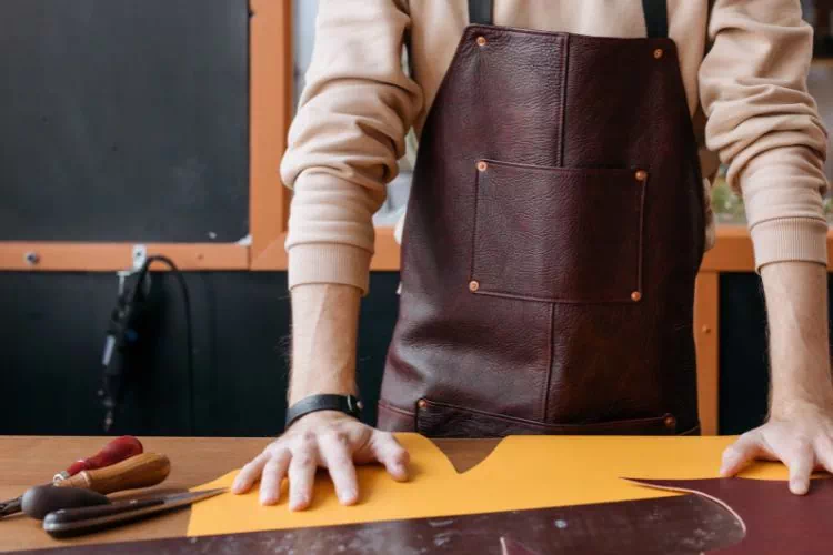 Homme en train de découper un patch en cuir autocollant à la bonne dimension