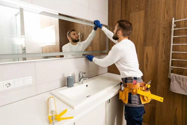 Professionnel en train de poser une glace dans une salle de bain