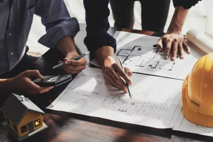 Deux personnes travaillant sur les plans d'un appartement