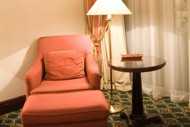 Petit coin lecture dans un salon avec un siège confortable, une petite table et un éclairage