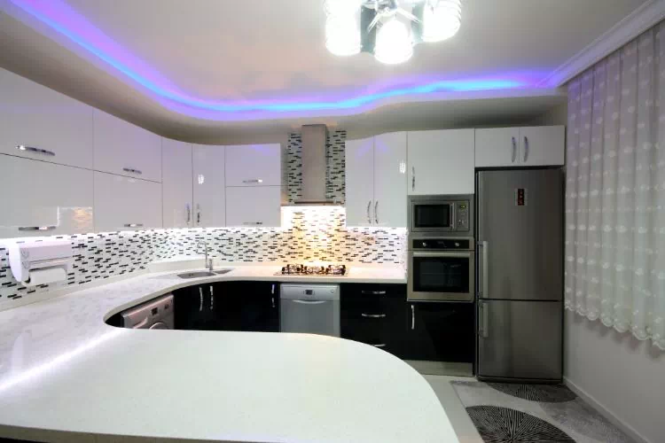 Cuisine avec un plan de travail et des meubles tout en arrondi