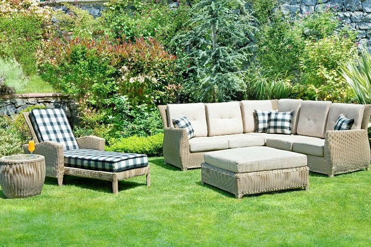 Salon de jardin avec une banquette, un canapé, un repose-pied et une table basse