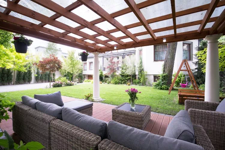 Salon de jardin avec canapés et fauteuils sous une pergola