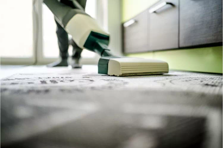 Personne passant l'aspirateur sur une moquette