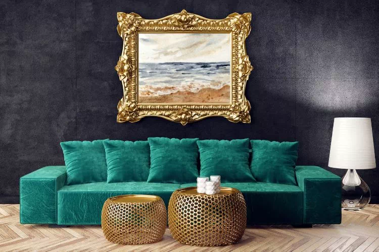 Grand canapé vert foncé sous un grand cadre doré