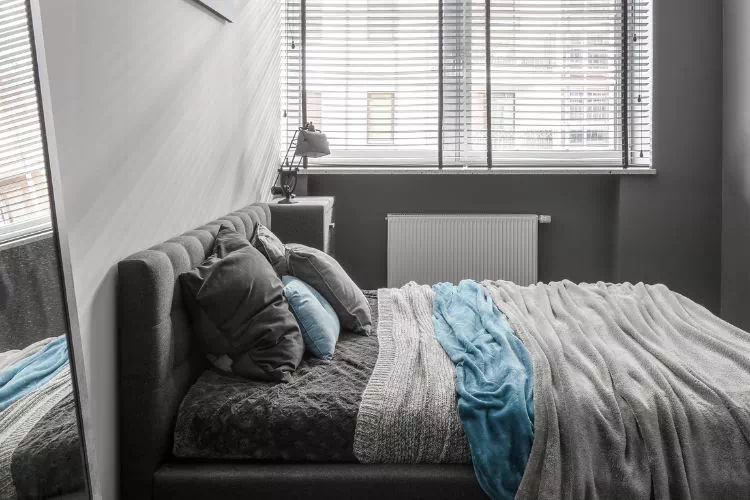 Petite chambre d'adulte avec le lit en travers