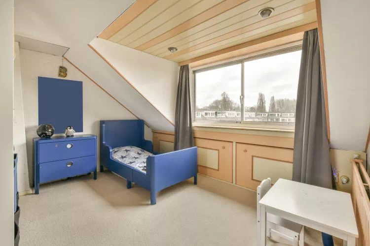 Petite chambre d'enfant avec une grande fenêtre