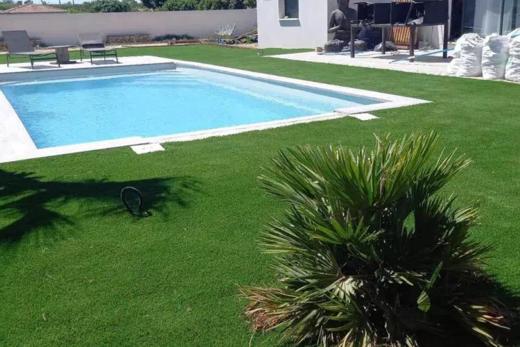 Piscine entourée de gazon artificiel