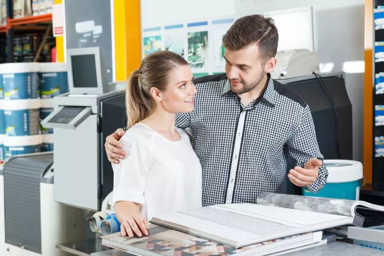 Couple en train de choisir un papier peint dans un magasin
