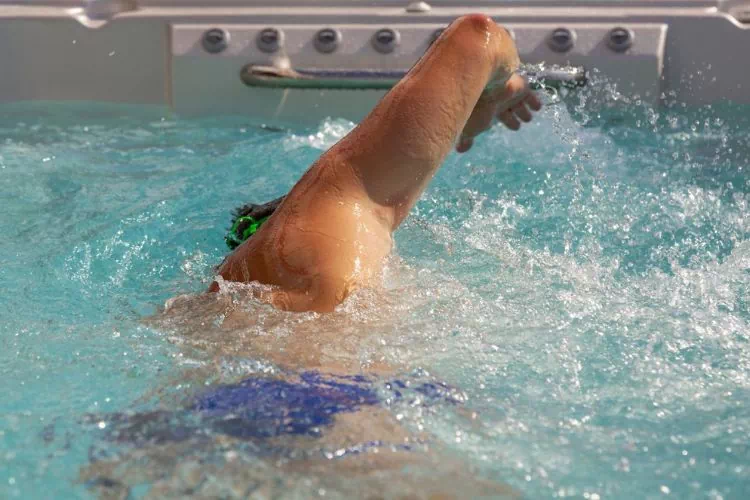 Homme nageant le crawl dans un spa de nage à contre-courant