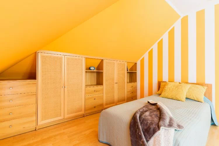 Chambre avec meubles de rangement sous pente