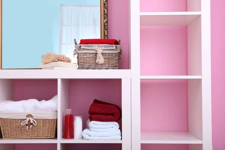 Étagères murales blanches dans une salle de bain rose