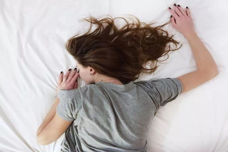 Adolescente allongée sur son lit en train de dormir