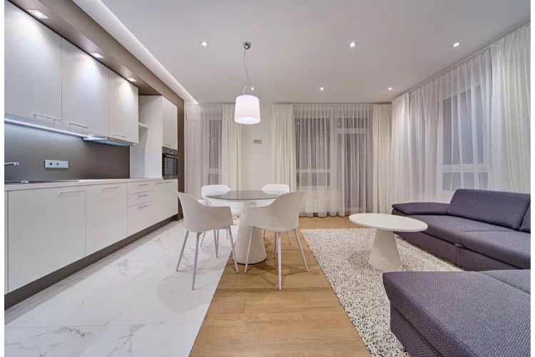 Cuisine avec sol en marbre ouverte sur salon avec plancher en bois