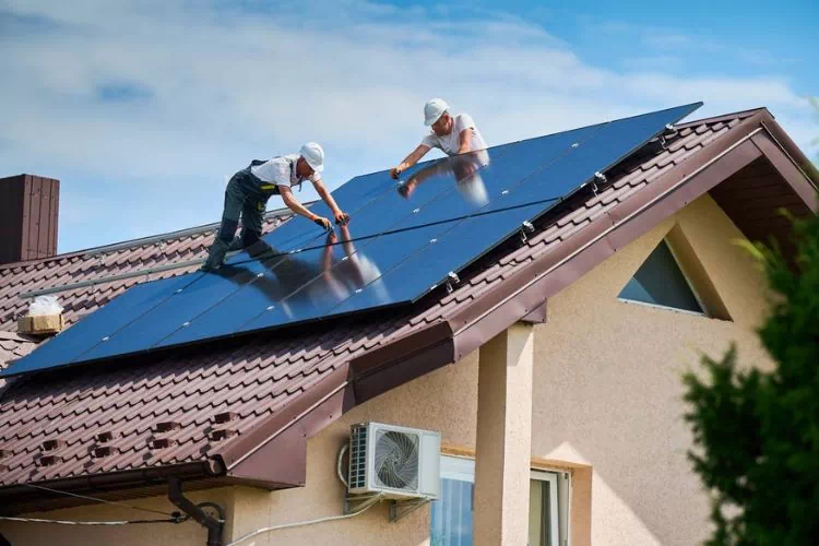 Ouvriers installant des panneaux solaires sur un toit