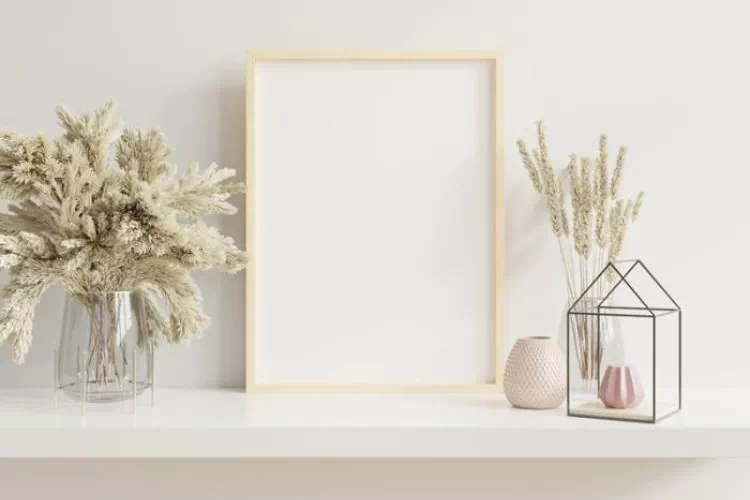 Cadre en bois clair disposé sur un rebord avec d'autres objets décoratifs