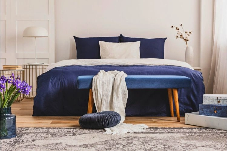 Chambre à coucher avec drap et coussins en bleu pétrole