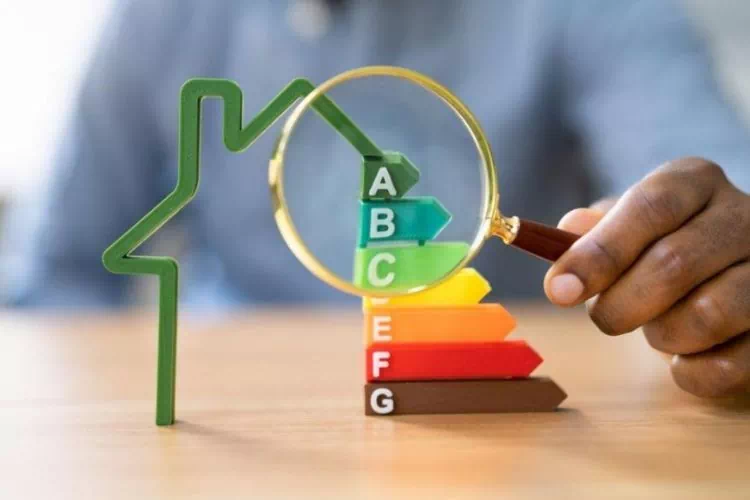 Homme tenant une loupe pour mieux voir la classe énergétique d'une maison