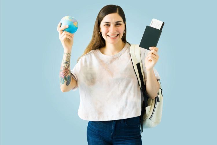 Femme tenant son passeport et un petit globe dans les mains