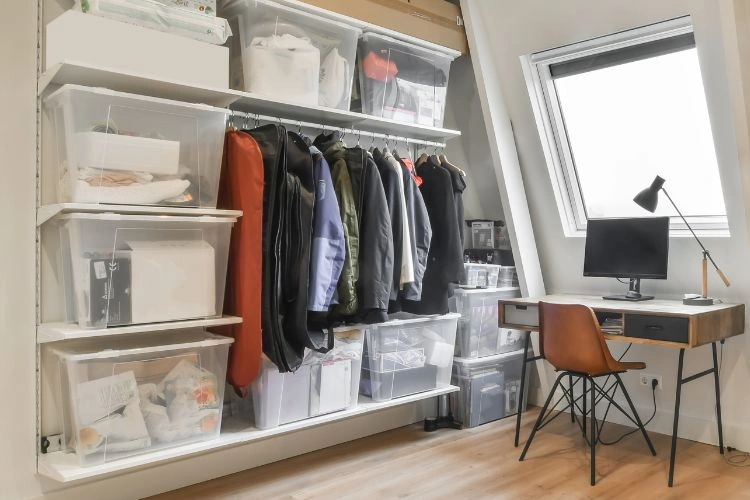 Petit dressing aménagé sous une pente dans un studio étudiant