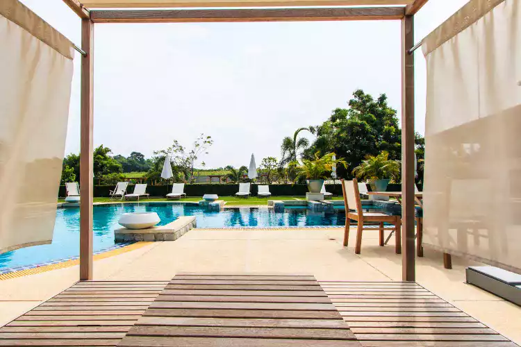 Piscine avec chaises longues et ombrage en bois