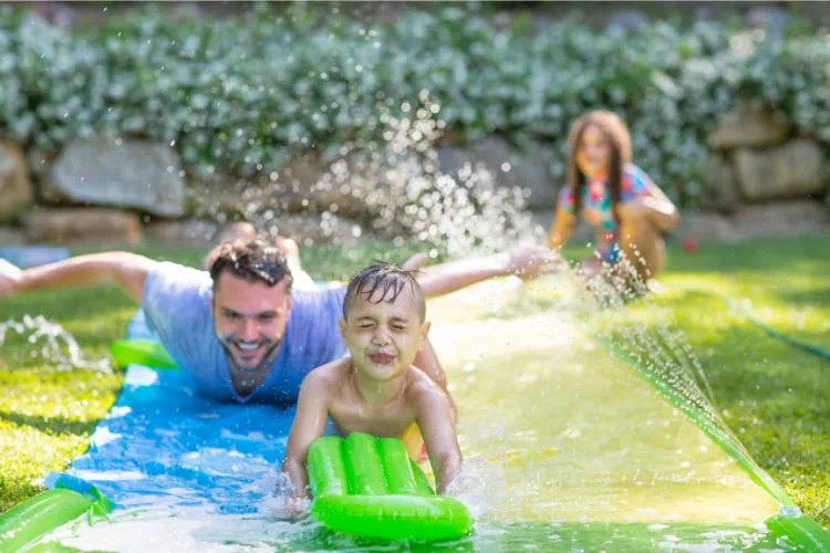 Famille dans le jardin jouant à des jeux aquatiques