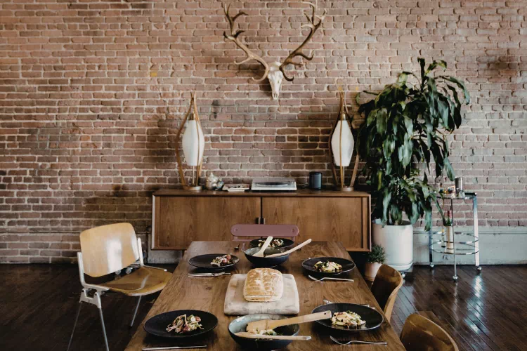 Salle à manger rustique avec murs en briques et un buffet