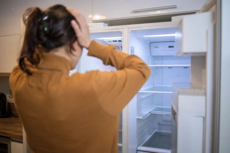 Personne déçu devant son frigo