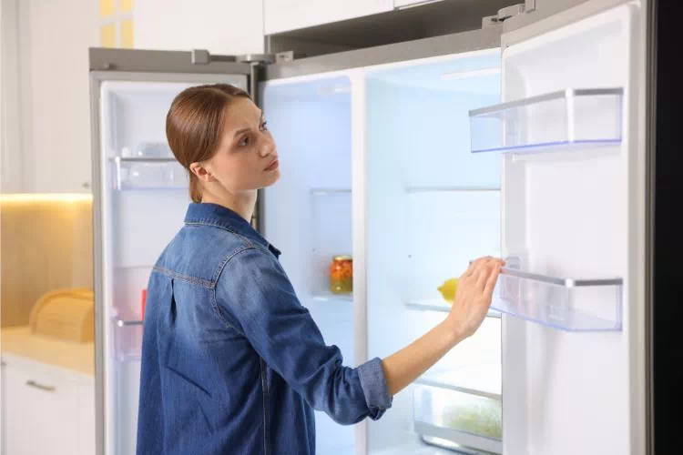 Femme vérifiant la température de son frigo