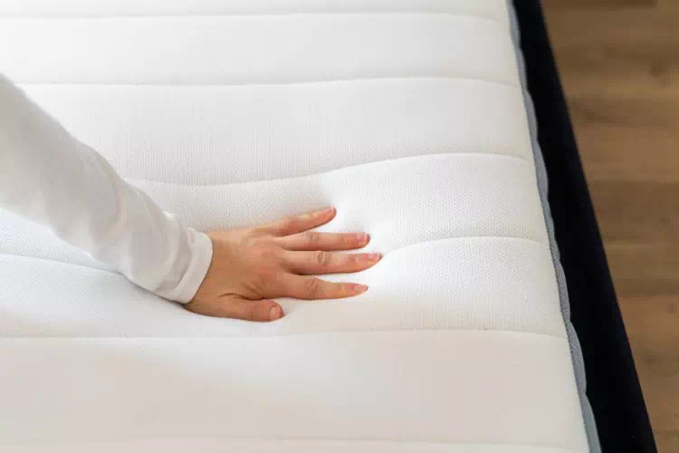Main testant la qualité d'un matelas