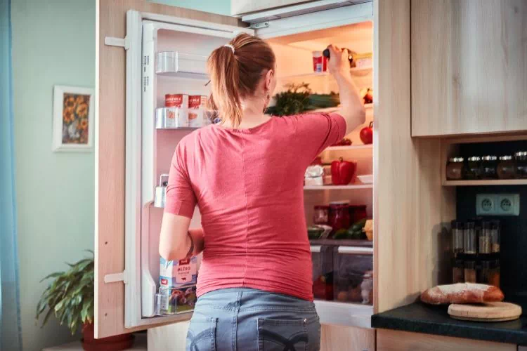 Femme devant son frigo