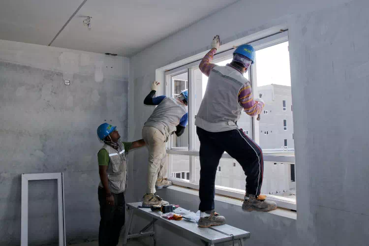 Ouvriers qui changent une fenêtre