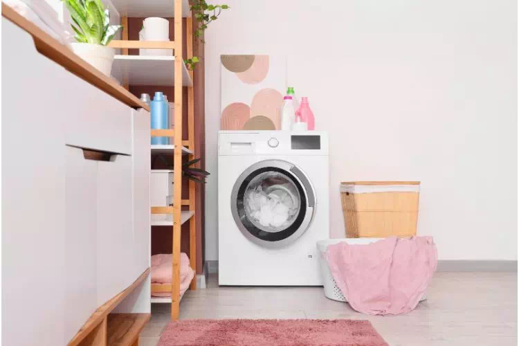 Buanderie avec machine à laver, meuble de rangement et plan de travail